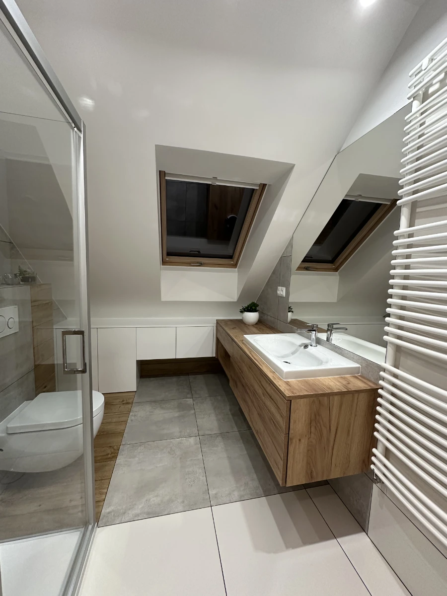 Minimalistyczna łazienka na poddaszu z drewnianymi akcentami