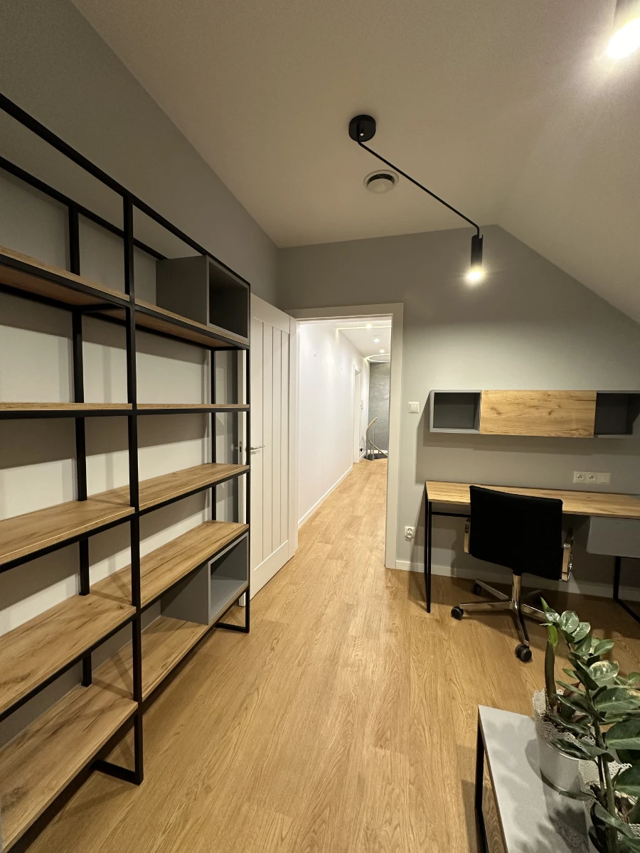 Domowe biuro na poddaszu z dużą ilością drewna i naturalnym doświetleniem