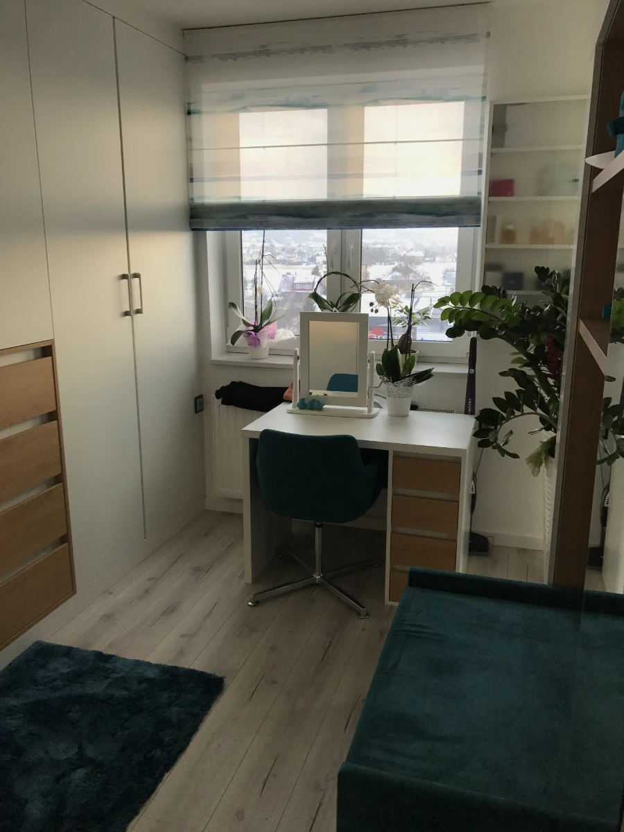 Mały pokój z toaletką umieszczoną przy oknie, świetnie zagospodarowany