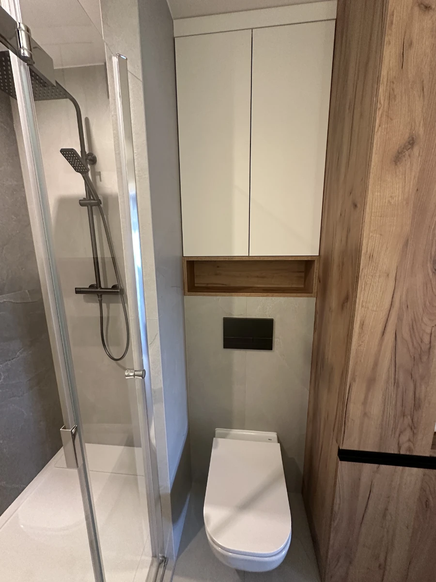 Sedes z zagospodarowaną przestrzenią za nim, wnęka ze szafką i drewniana szafa obok