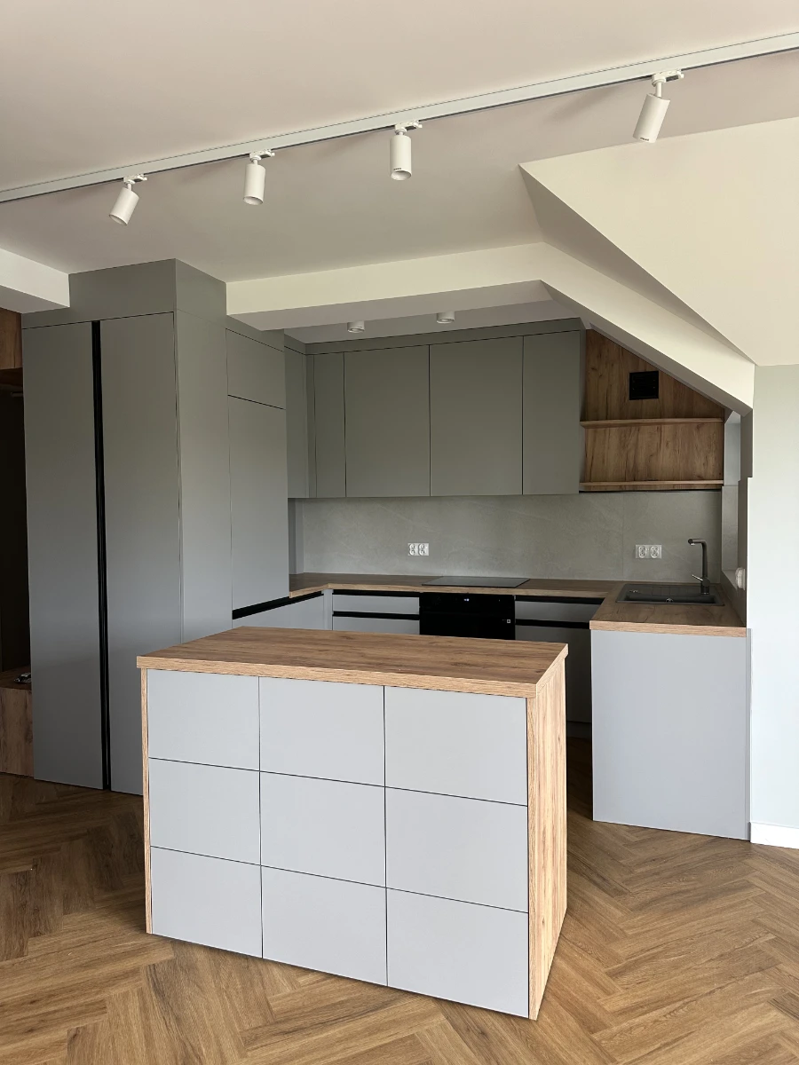 Minimalistyczna i estetyczna wysepka kuchenna widziana od strony naprzeciwko kuchni