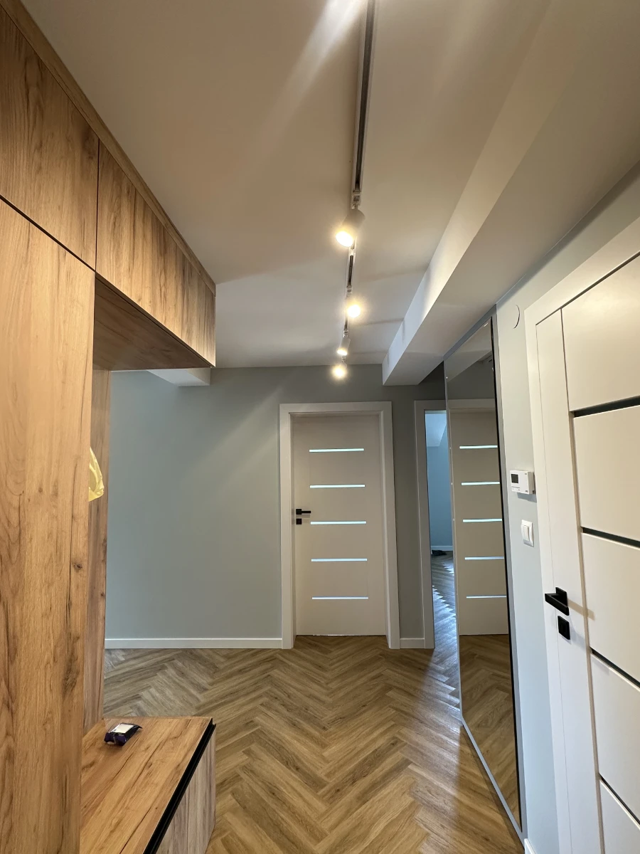 Przedpokój z dużą ilością drewnianych elementów widziany zaraz po wejściu