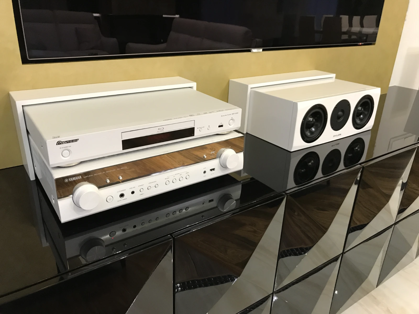 Biała szafka RTV na wysoki połysk z nowoczesnym sprzętem audio-wideo